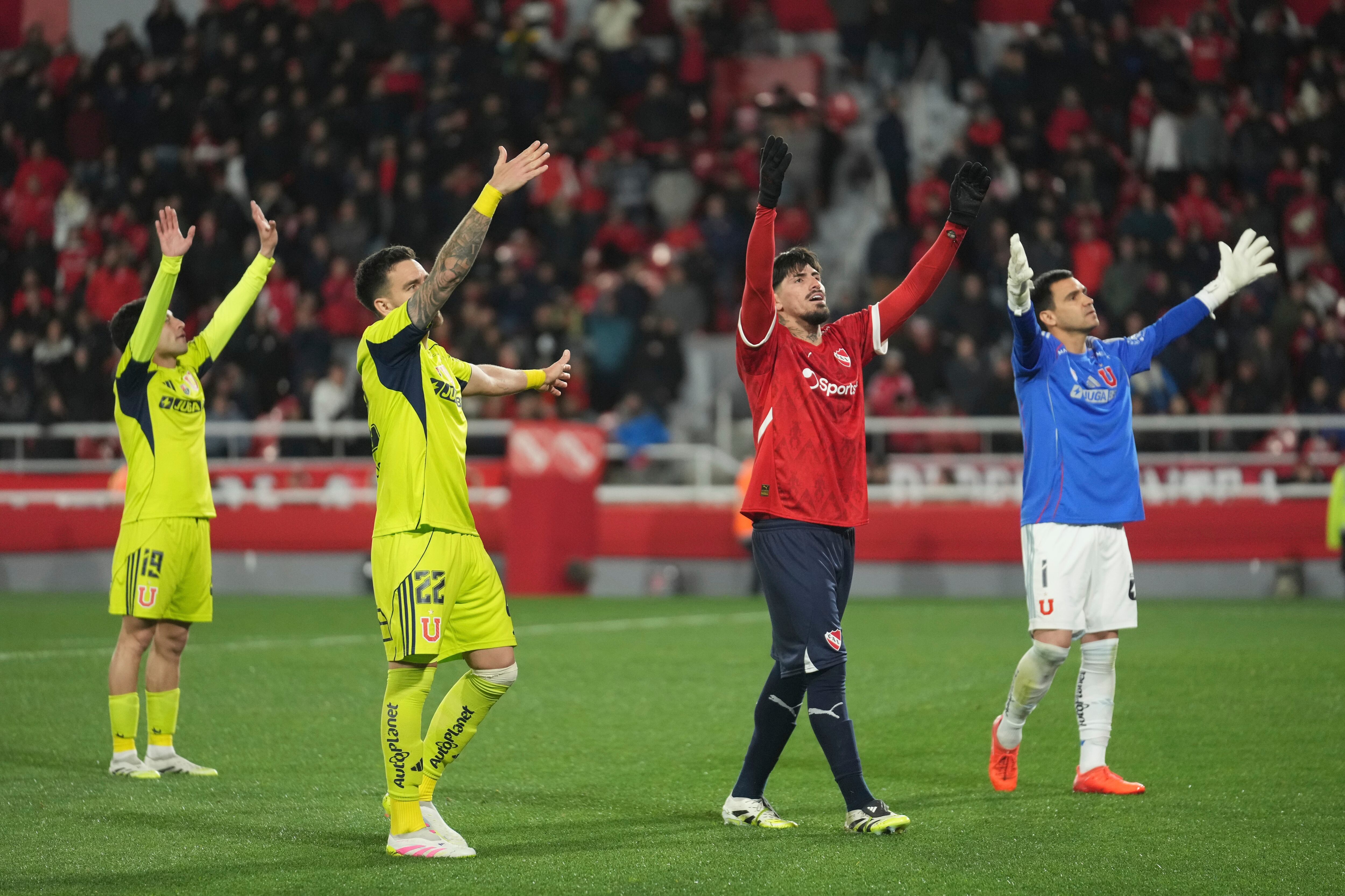 Players try to calm their fans during a Copa Sudamericana round of sixteen second leg soccer match between Universidad de Chile and Argentina's Independiente at the Libertadores de America stadium in Avellaneda, Argentina, Wednesday, Aug. 20, 2025. (AP Photo/Gustavo Garello)