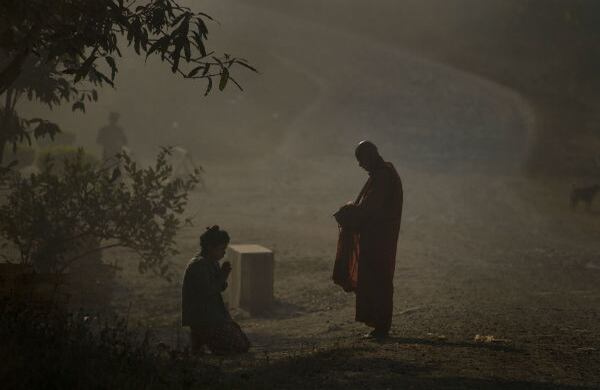Un devoto budista reza después de ofrecerle limosna a un monje en Shan State, en Birmania. (AP)