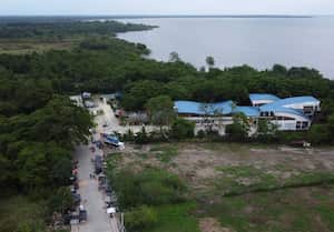 Vista aérea que muestra a migrantes varados, en su mayoría venezolanos, esperando en tiendas de campaña improvisadas en la ciudad portuaria de Turbo, Colombia, cerca del Tapón del Darién, una selva compartida por Colombia y Panamá, antes de continuar su viaje hacia Estados Unidos con la esperanza de una mejor situación. (Foto de Juan RESTREPO / AFP)