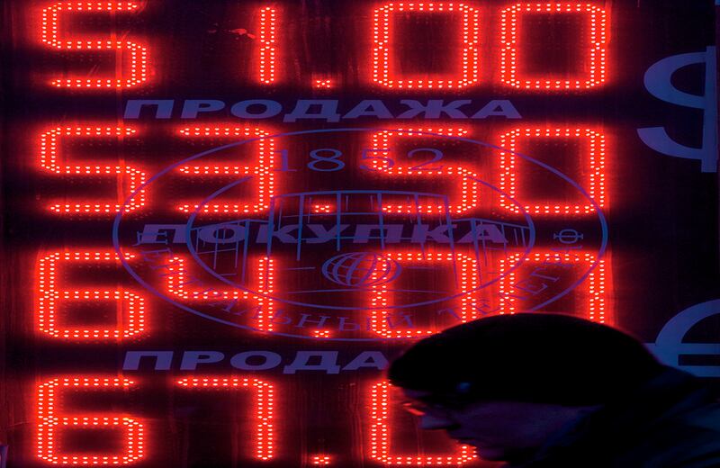 Un hombre camina frente a una cabina de cambio de divisas en Moscú. Por primera vez el gobierno ruso admitió que el país caerá en recesión el próximo año, debido al desplome de los precios del petróleo. (AP)