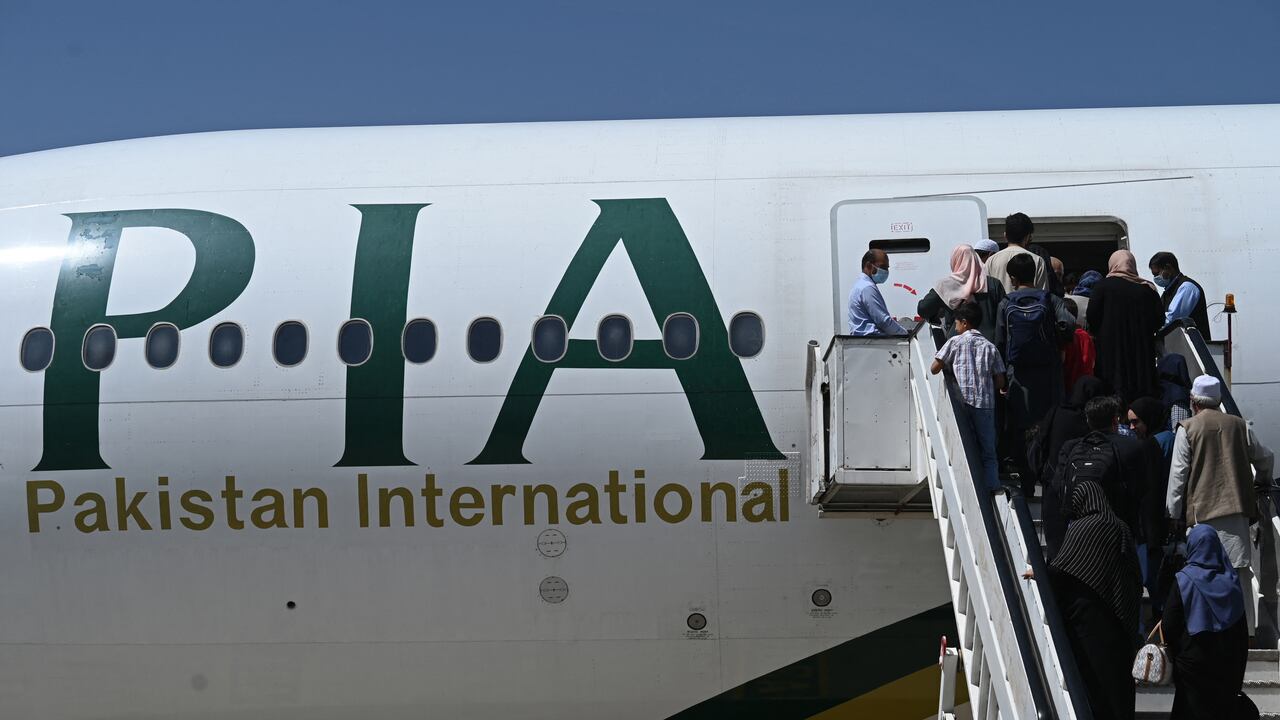 Los pasajeros abordan un vuelo de Pakistan International Airlines (PIA), el primer vuelo internacional comercial desde que los talibanes recuperaron el poder el mes pasado, en el aeropuerto de Kabul el 13 de septiembre de 2021 (Foto de Aamir QURESHI / AFP).