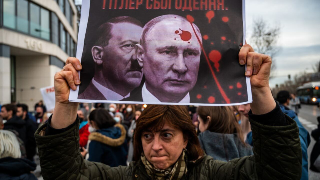 Una mujer es vista con un cartel que muestra las imágenes de Putin y Hitler durante una protesta después de los primeros ataques rusos registrados en Ucrania. Los ucranianos residentes en Madrid se concentraron, el 24 de febrero de 2022, frente a la embajada rusa para protestar contra los ataques rusos registrados en varios puntos del país ucraniano exigiendo el fin de la guerra y gritando consignas contra el presidente ruso Vladimir Putin. (Foto de Marcos del Mazo/LightRocket vía Getty Images)