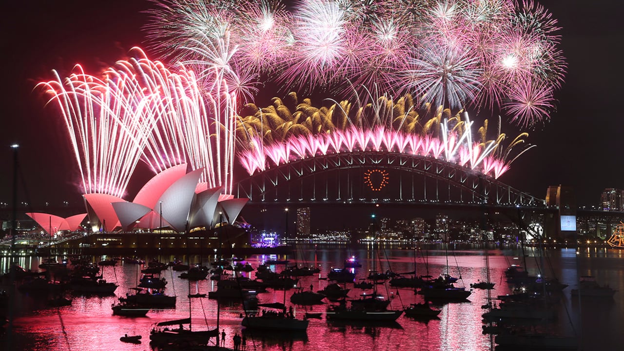 Fuegos artificiales explotan sobre la icónica Casa de la Ópera en Sídney, Australia.