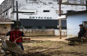 Entre el invierno y la guerra. Tal es la suerte del Catatumbo, como lo muestra esta imagen tomada en La Gabarra. Al frente, trabajadores sacan tierra de una casa ahogada por la inundación que, en noviembre, invadió varias calles del pueblo. Al fondo la fachada de la estación de policía ennegrecida y perforada por las explosiones y los disparos de la guerrilla.