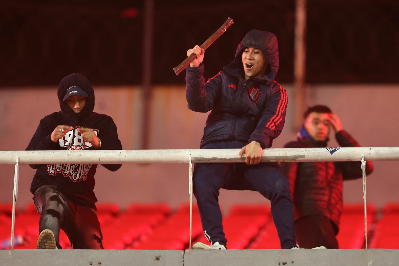 Un aficionado de la Universidad de Chile sostiene una barra de acero durante la interrupción del partido de vuelta de los octavos de final de la Copa Sudamericana entre Independiente de Argentina y la Universidad de Chile de Chile.