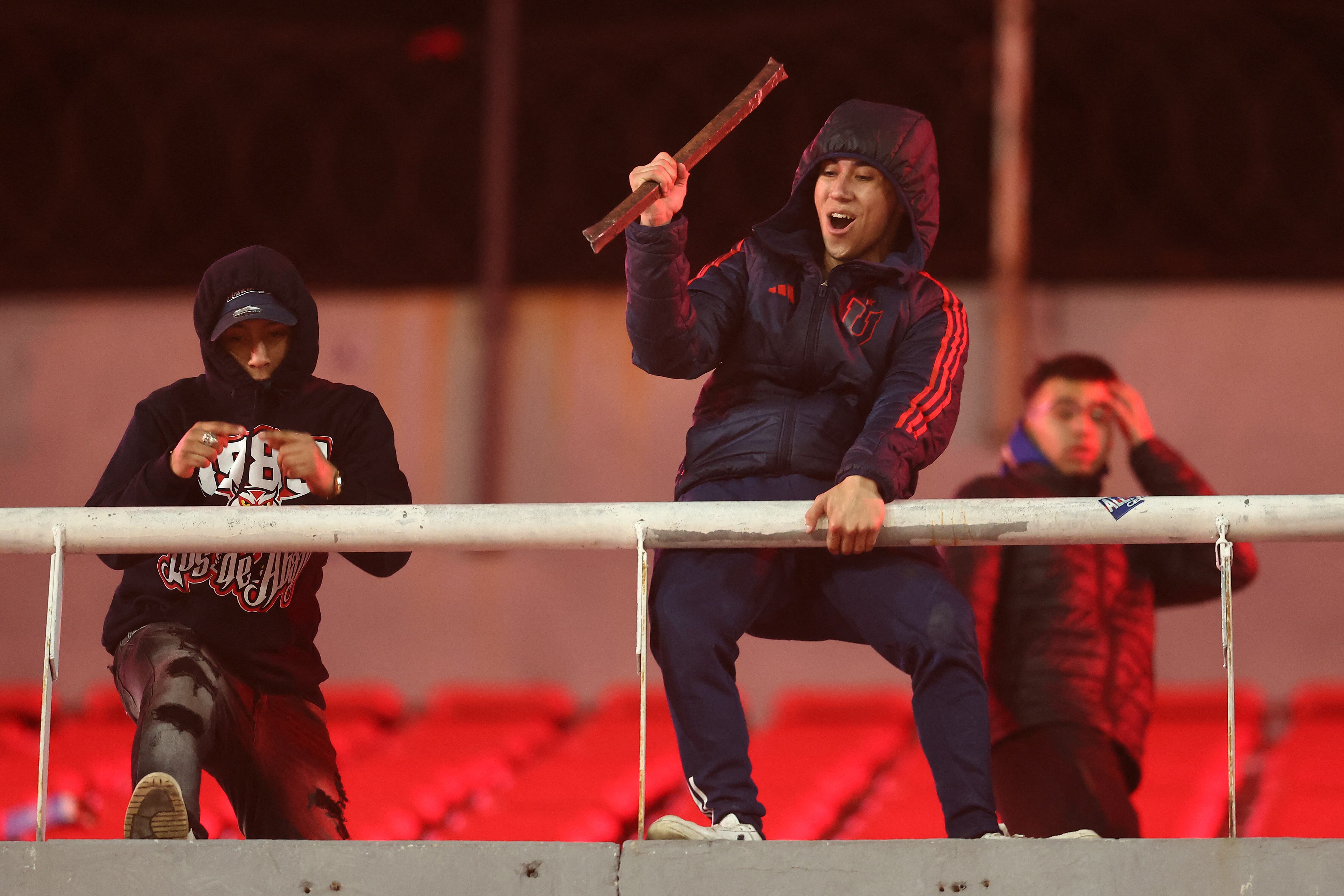 Un aficionado de la Universidad de Chile sostiene una barra de acero durante la interrupción del partido de vuelta de los octavos de final de la Copa Sudamericana entre Independiente de Argentina y la Universidad de Chile de Chile.