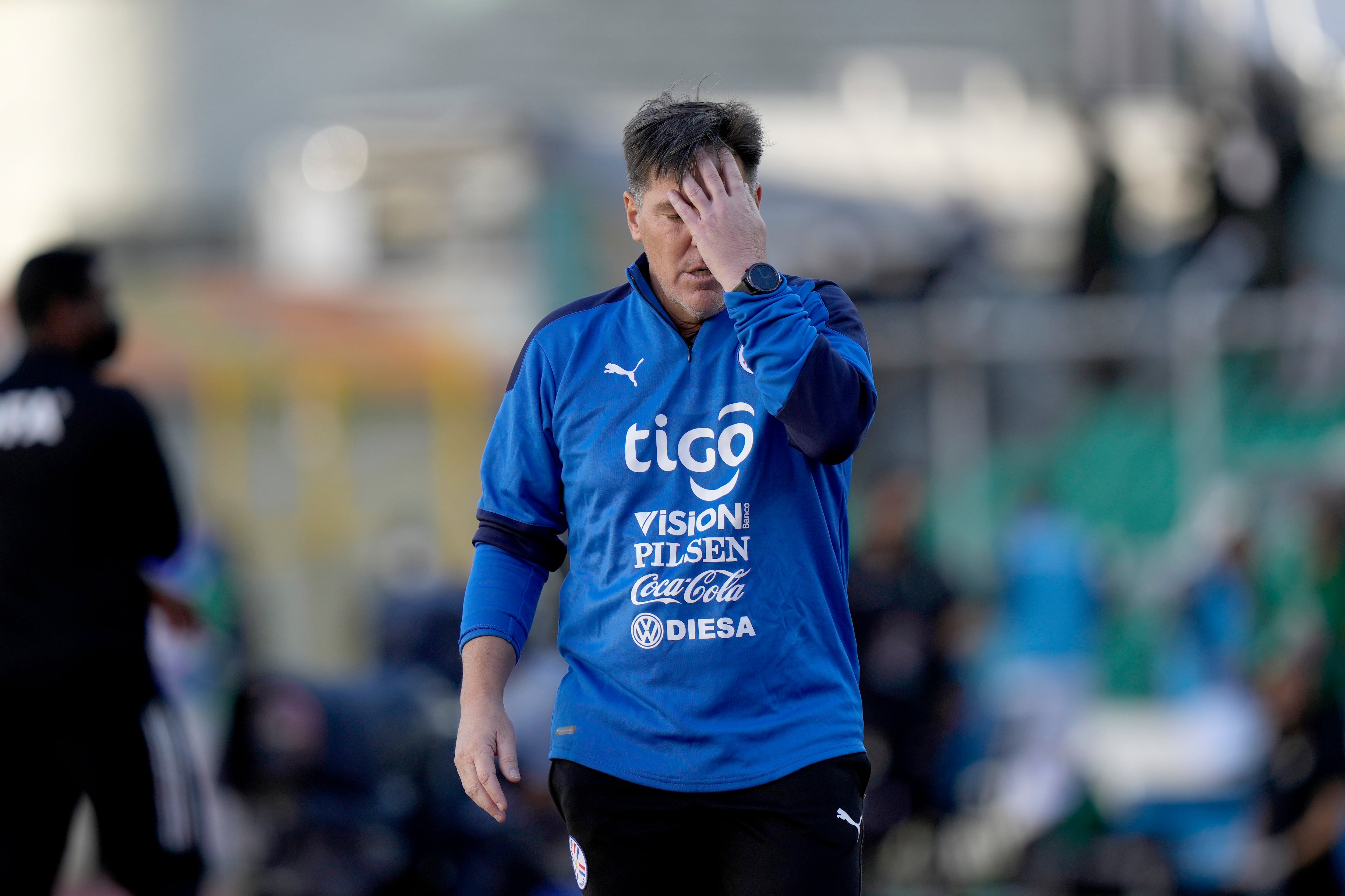 El argentino Eduardo Berizzo, técnico de la selección de Paraguay, se lleva una mano al rostro durante el encuentro que perdió ante Bolivia, en las eliminatorias mundialistas, el jueves 14 de octubre de 2021 (AP Foto/Juan Karita)