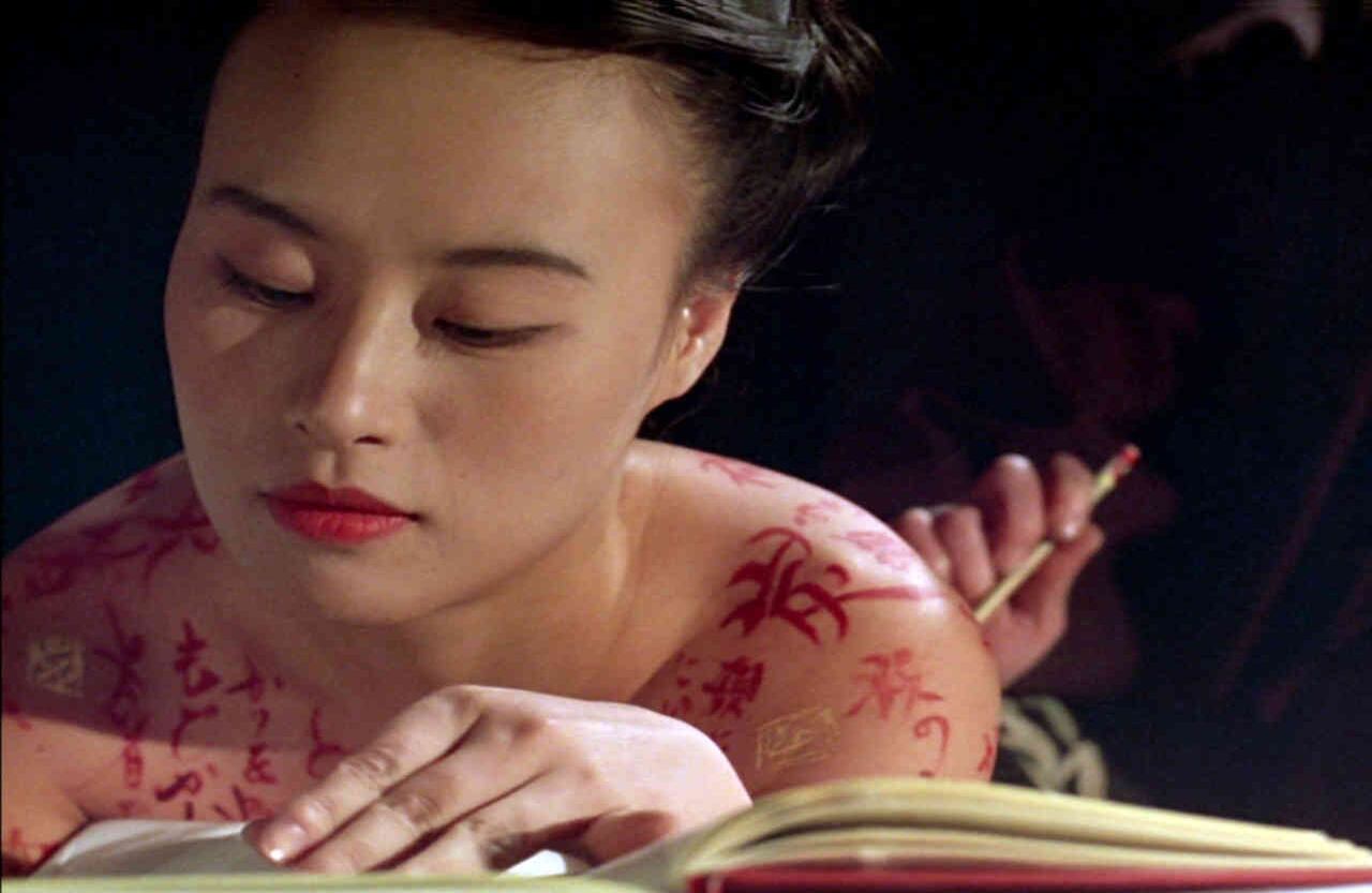 'Escrito en el cuerpo' (1996)  La película dirigida por Peter Greenaway cuenta la historia de Nagiko, que como narradora y protagonista narra su proceso de aprendizaje. El símbolo que representa tal proceso es el paso de ser soporte de escritura a convertirse en pincel. Durante la transformación experimenta el conocimiento del amor, la muerte y la venganza. El título original de la cinta, ‘The pillow book’, hace referencia a la costumbre japonesa de guardar los diarios íntimos en las almohadas, que eran de cerámica o madera. 