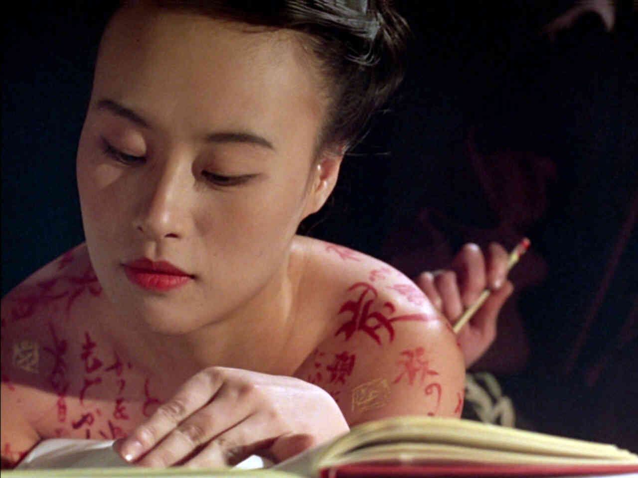 'Escrito en el cuerpo' (1996)  La película dirigida por Peter Greenaway cuenta la historia de Nagiko, que como narradora y protagonista narra su proceso de aprendizaje. El símbolo que representa tal proceso es el paso de ser soporte de escritura a convertirse en pincel. Durante la transformación experimenta el conocimiento del amor, la muerte y la venganza. El título original de la cinta, ‘The pillow book’, hace referencia a la costumbre japonesa de guardar los diarios íntimos en las almohadas, que eran de cerámica o madera. 