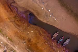 Embarcaciones languidecen sobre los últimos charcos de agua disponibles en el arroyo Payagua que llega al río Paraguay en medio de una histórica sequía que está afectando sus niveles, en Chaco-i, Paraguay, el lunes 20 de septiembre de 2021. Foto AP / Jorge Saenz