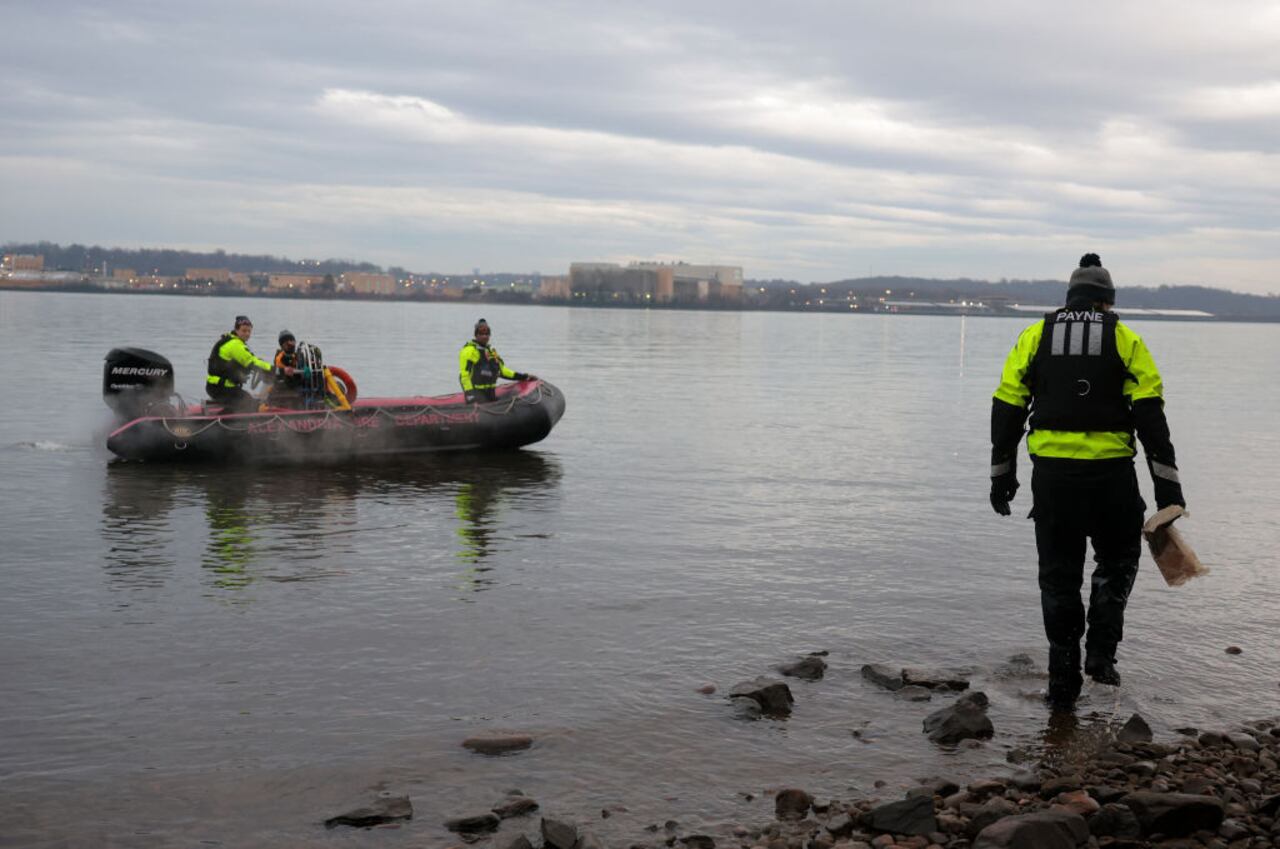 ALEXANDRIA, VIRGINIA - JANUARY 31: Members of the Alexandria Fire Department look for debris near the crash site of an American Airlines plane along the shoreline of the Potomac River on January 31, 2025 in Alexandria, Virginia. The American Airlines flight from Wichita, Kansas collided midair with a military Black Hawk helicopter while on approach to Ronald Reagan Washington National Airport. According to reports, there were no survivors among the 67 people on both aircraft. (Photo by Kayla Bartkowski/Getty Images)