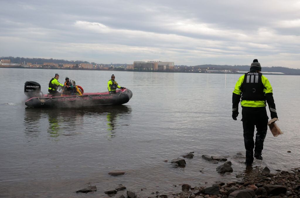 ALEXANDRIA, VIRGINIA - JANUARY 31: Members of the Alexandria Fire Department look for debris near the crash site of an American Airlines plane along the shoreline of the Potomac River on January 31, 2025 in Alexandria, Virginia. The American Airlines flight from Wichita, Kansas collided midair with a military Black Hawk helicopter while on approach to Ronald Reagan Washington National Airport. According to reports, there were no survivors among the 67 people on both aircraft. (Photo by Kayla Bartkowski/Getty Images)