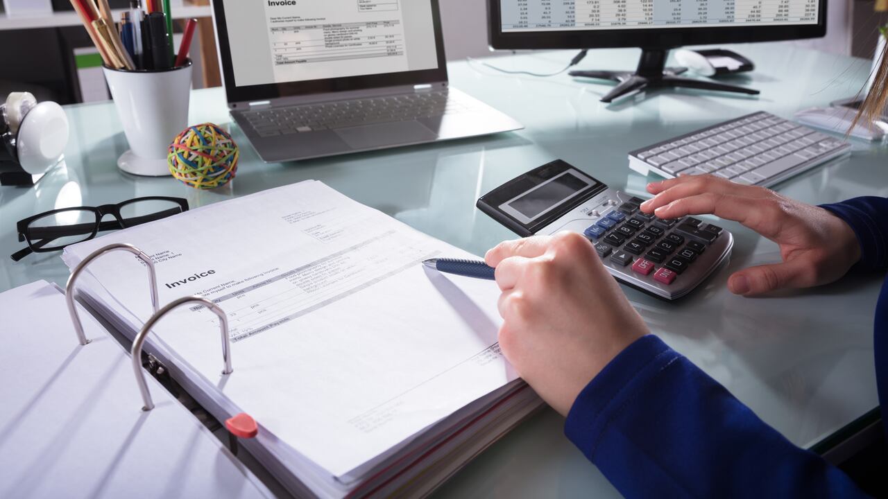 Close-up de la mano de un empresario calcular la factura en el lugar de trabajo
