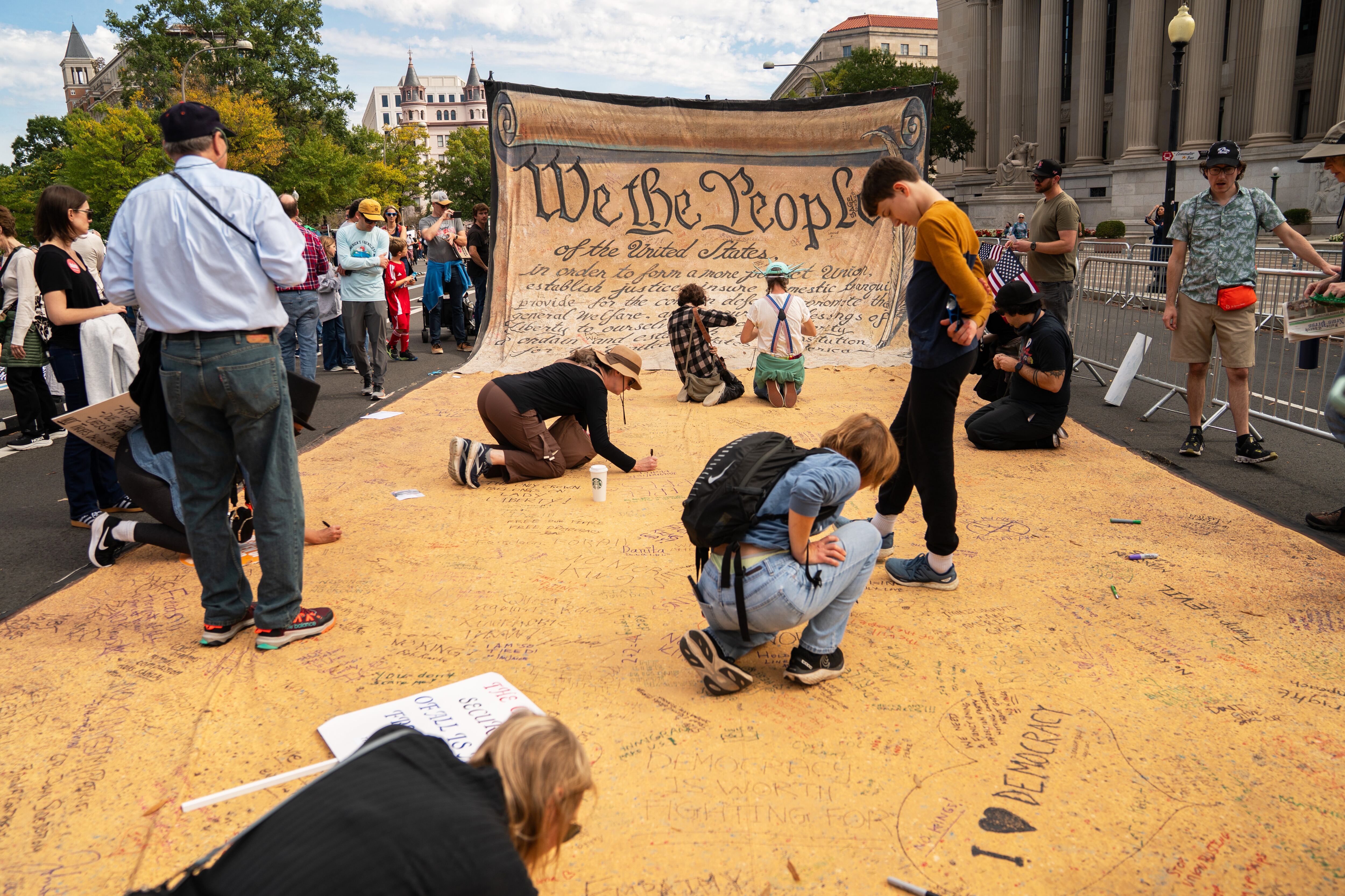 Los asistentes firman una pancarta que representa la Constitución de Estados Unidos durante una protesta contra la violencia doméstica en Washington.