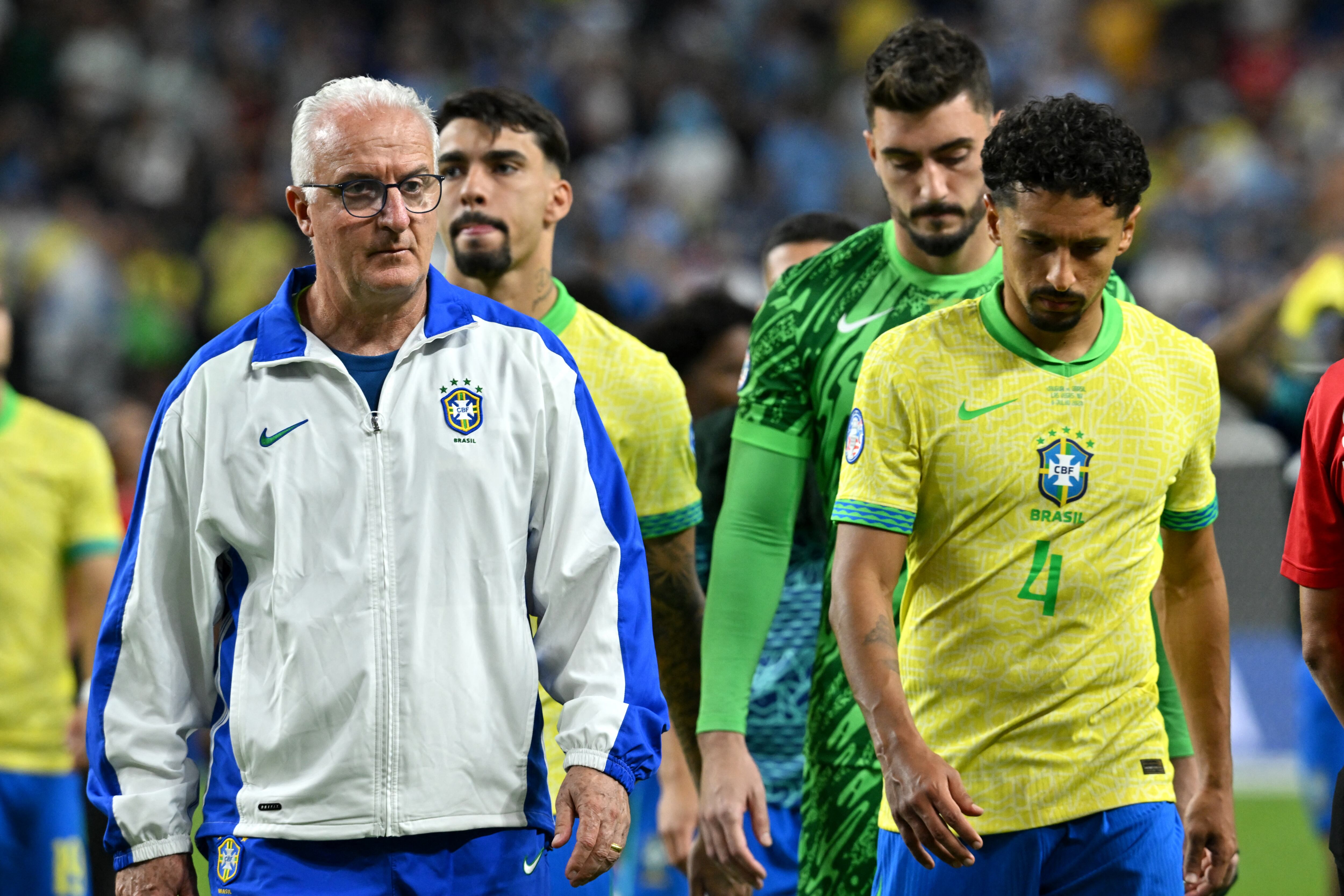 Brazil's coach Dorival Junior (L) and Brazil's defender #04 Marquinhos react after their team's defeat in the Conmebol 2024 Copa America tournament quarter-final football match between Uruguay and Brazil at Allegiant Stadium in Las Vegas, Nevada on July 6, 2024. (Photo by Robyn BECK / AFP)