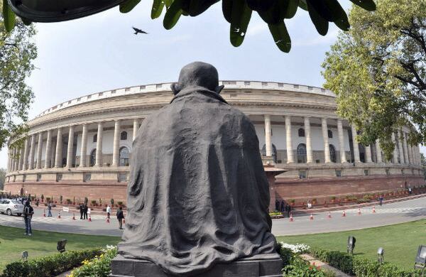 Una estatua de Mahatma Gandhi es fotografiada con el Parlamento al fondo, en Nueva Delhi, India. (EFE)