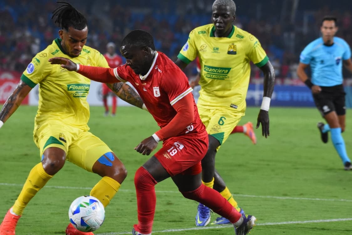 Tilman Palacios contra dos jugadores del Bucaramanga.