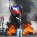 Un manifestante sostiene una bandera de Haití durante una protesta para exigir la renuncia del primer ministro Ariel Henry, el viernes 1 de marzo de 2024, en Puerto Príncipe. (AP Foto/Odelyn Joseph)