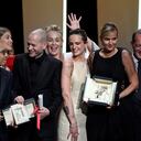 French director Julia Ducournau (C) poses on stage with guests and laureates after she won the Palme d'Or for her film "Titane" during the closing ceremony of the 74th edition of the Cannes Film Festival in Cannes, southern France, on July 17, 2021. (Photo by CHRISTOPHE SIMON / AFP)