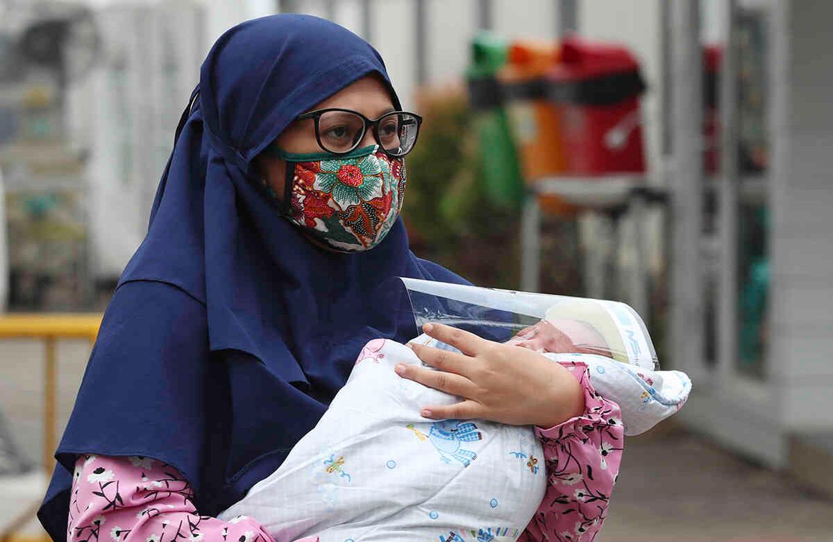 Una mujer musulmana lleva a su bebé al hospital de Yakarta, Indonesia, el 28 de abril. Los musulmanes del mundo han comenzado el Ramadán, el mes de ayuno, oración, reflexión y comunidad, en medio de las restricciones impuestas para frenar la pandemia de covid-19. Foto: Achmad Ibrahim/ AP