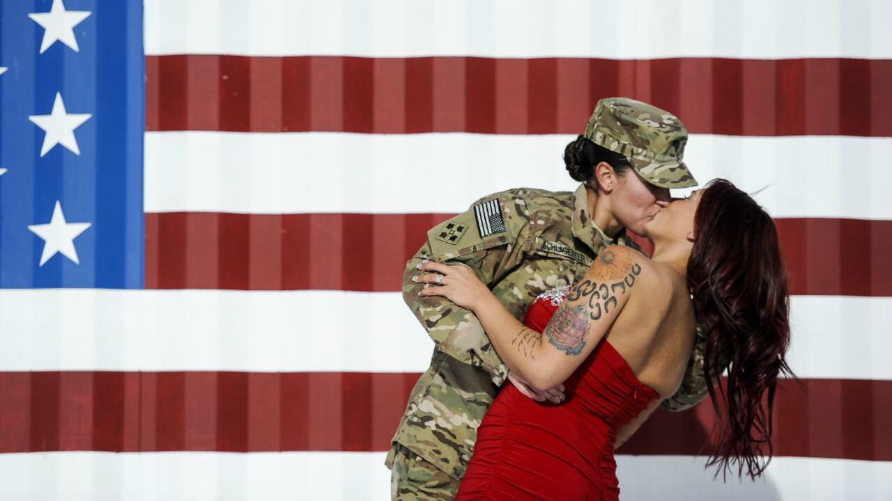 Sabryna Schlagetter (izquierda) besa a su esposa, Cheyenne Schlagetter, después de regresar a casa a Fort Carson, Colorado, el 14 de noviembre, con su equipo de combate de cuarta Brigada de Infantería.
