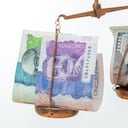 tipos de cambio, peso colombiano frente al dólar estadounidense, fondo blanco, concepto financiero, billetes a pequeña escala