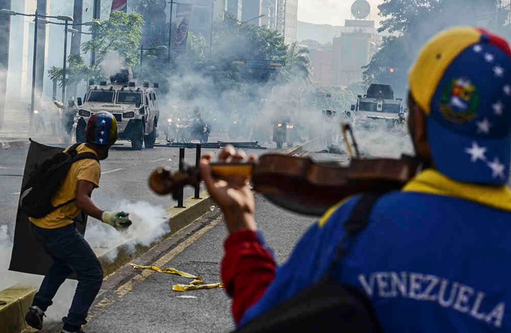 Interpretando con un violín el himno de Venezuela y el tradicional joropo Alma Llanera, Wuilly Arteaga avanzó el 8 de mayo hacia los cuerpos de seguridad bajo una lluvia de bombas lacrimógenas. Fue su homenaje a un músico de 17 años muerto días antes en una manifestación.