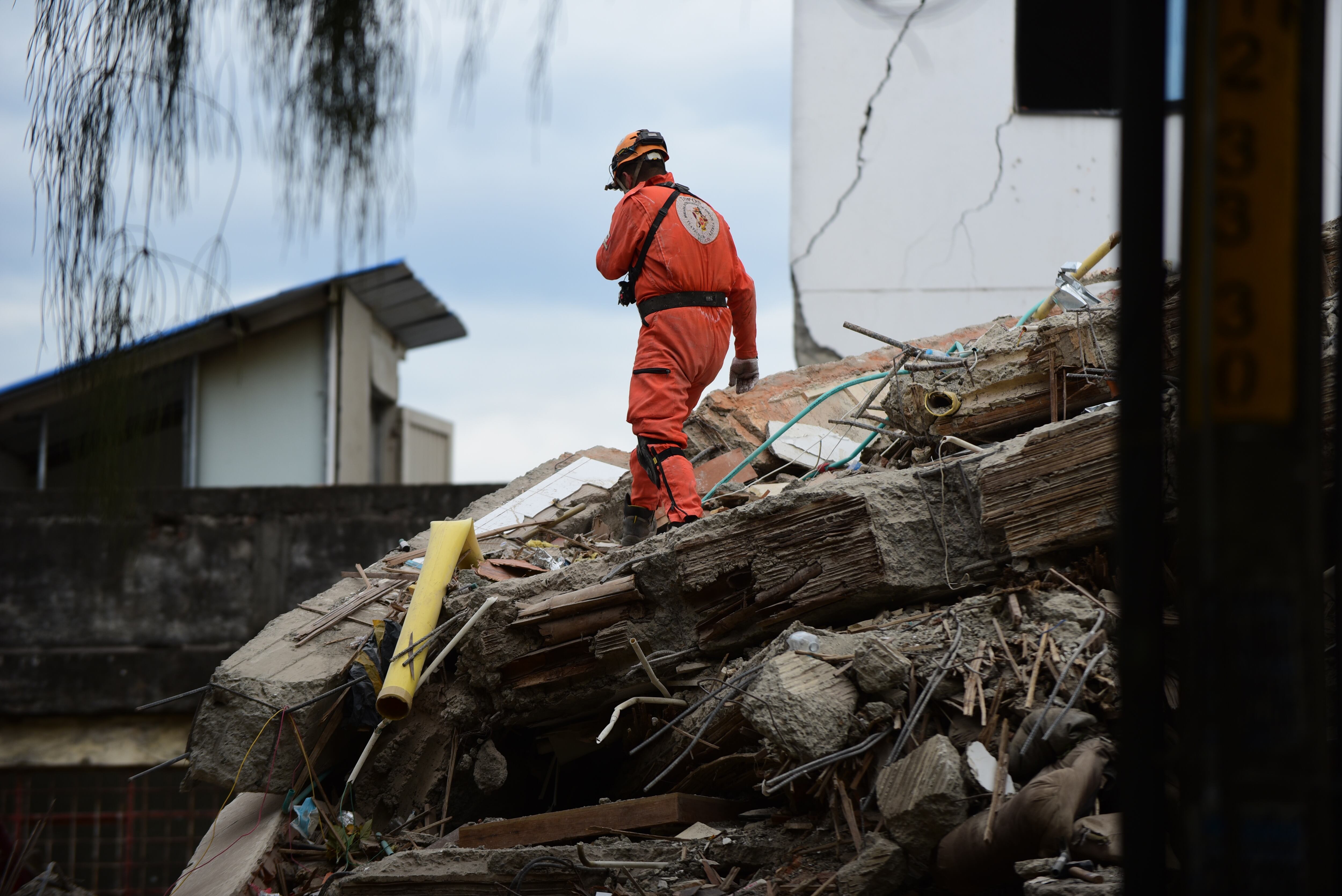 Miembros de organismos de respuesta a emergencias —incluidos el Cuerpo de Bomberos, el Ejército de Colombia y el grupo de rescate mexicano Topos Aztecas— buscan supervivientes entre los escombros de estructuras colapsadas en Cali, Colombia, el 12 de agosto de 2026.