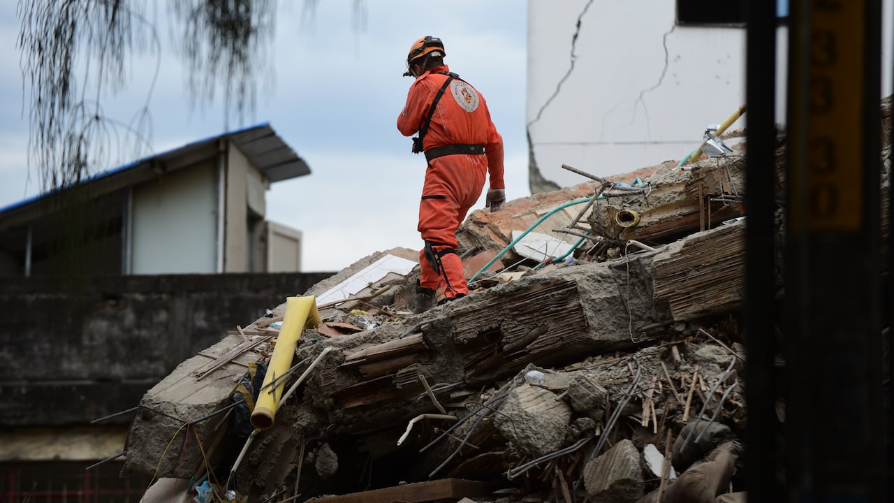 Miembros de organismos de respuesta a emergencias —incluidos el Cuerpo de Bomberos, el Ejército de Colombia y el grupo de rescate mexicano Topos Aztecas— buscan supervivientes entre los escombros de estructuras colapsadas en Cali, Colombia, el 12 de agosto de 2026.