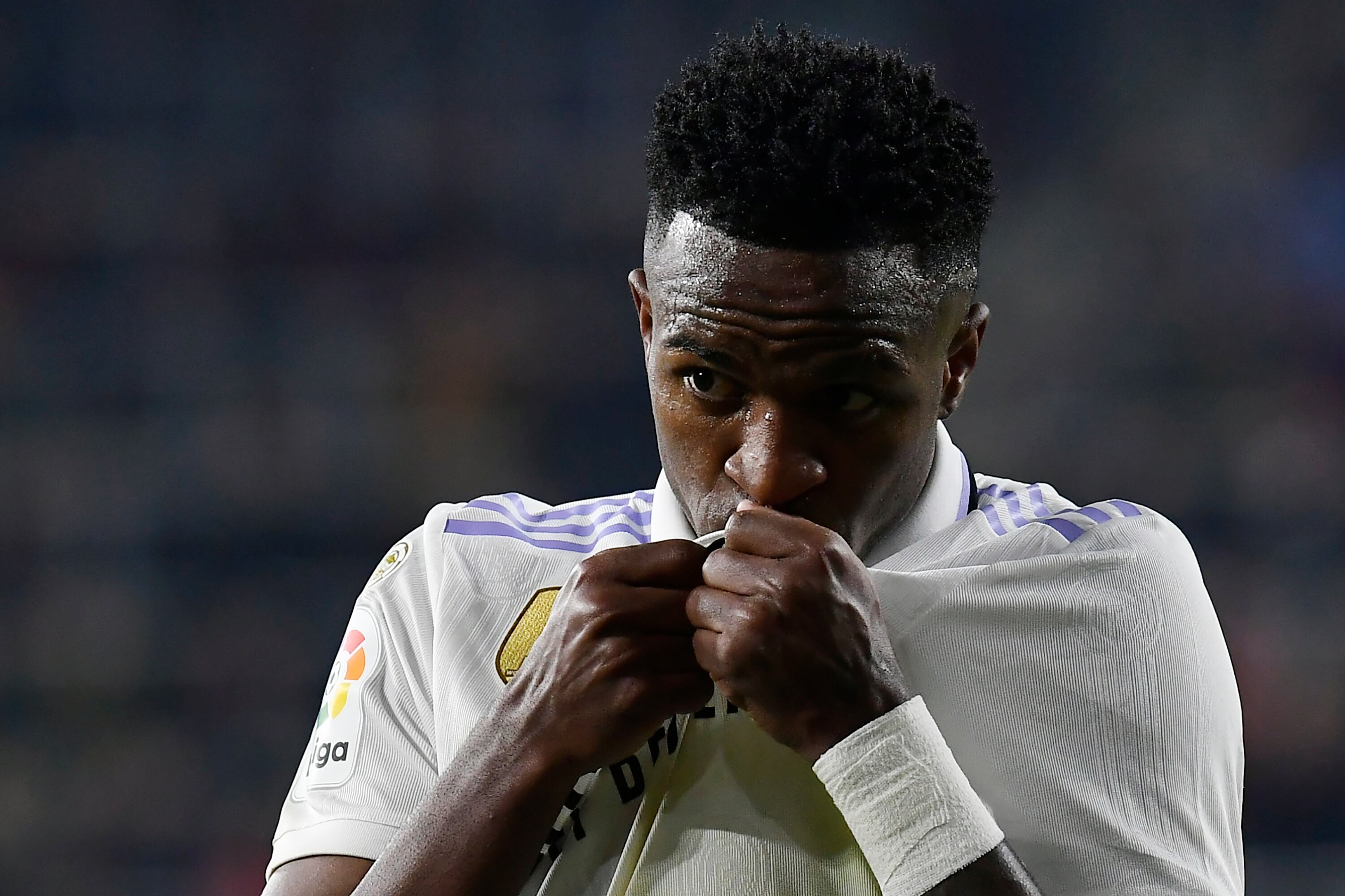 Vinicius Junior del Real Madrid besa el escudo del equipo tras el gol de su compañero Federico Valverde ante Osasuna en la Liga española, el sábado 18 de febrero de 2023. (AP Foto/Alvaro Barrientos)