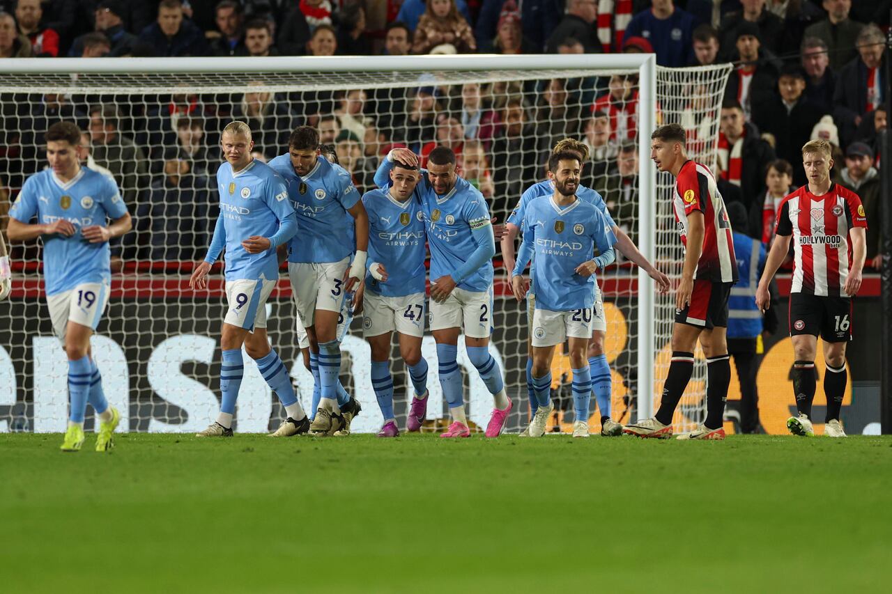 Phil Foden, centro, del Manchester City, celebra con sus compañeros de equipo después de anotar el primer gol de su equipo durante el partido de fútbol de la Liga Premier inglesa entre Brentford y Manchester City en el Gtech Community Stadium de Londres, el lunes 5 de febrero de 2024. (Foto AP/Ian Walton )