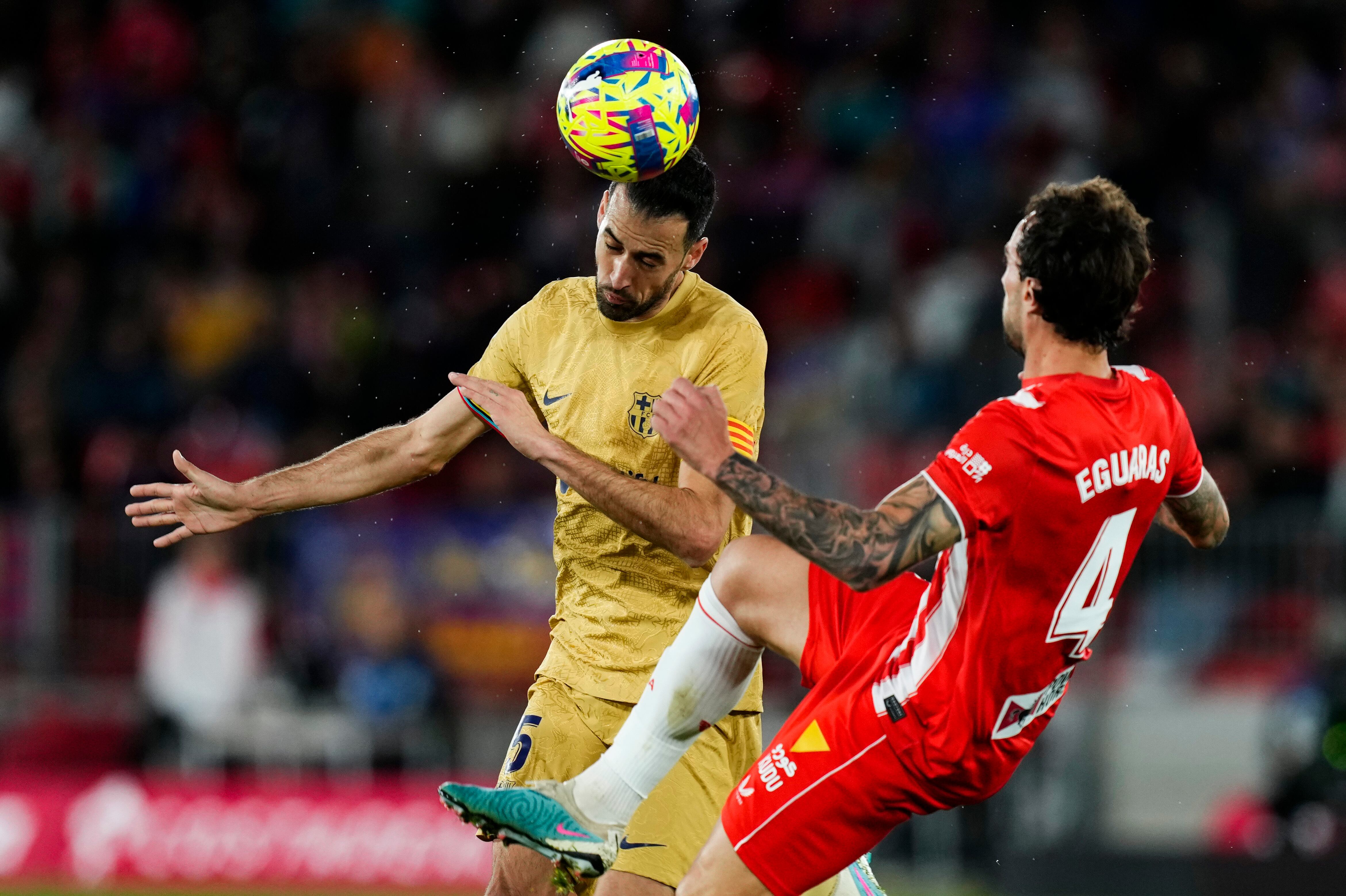 Barcelona's Sergio Busquets, left, heads the ball next to Almeria's Inigo Eguaras during the Spanish La Liga soccer match between Almeria and Barcelona at the Juegos Mediterraneos stadium in Almeria, Spain, Sunday, Feb. 26, 2023. (AP Photo/Jose Breton)