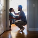 Father measuring daughter's height against wall