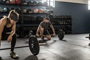 Personas descansando tras una serie de entrenamientos en el gimnasio