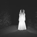 One woman, she masked herself in a scary witch for halloween, standing on the street, black and white.