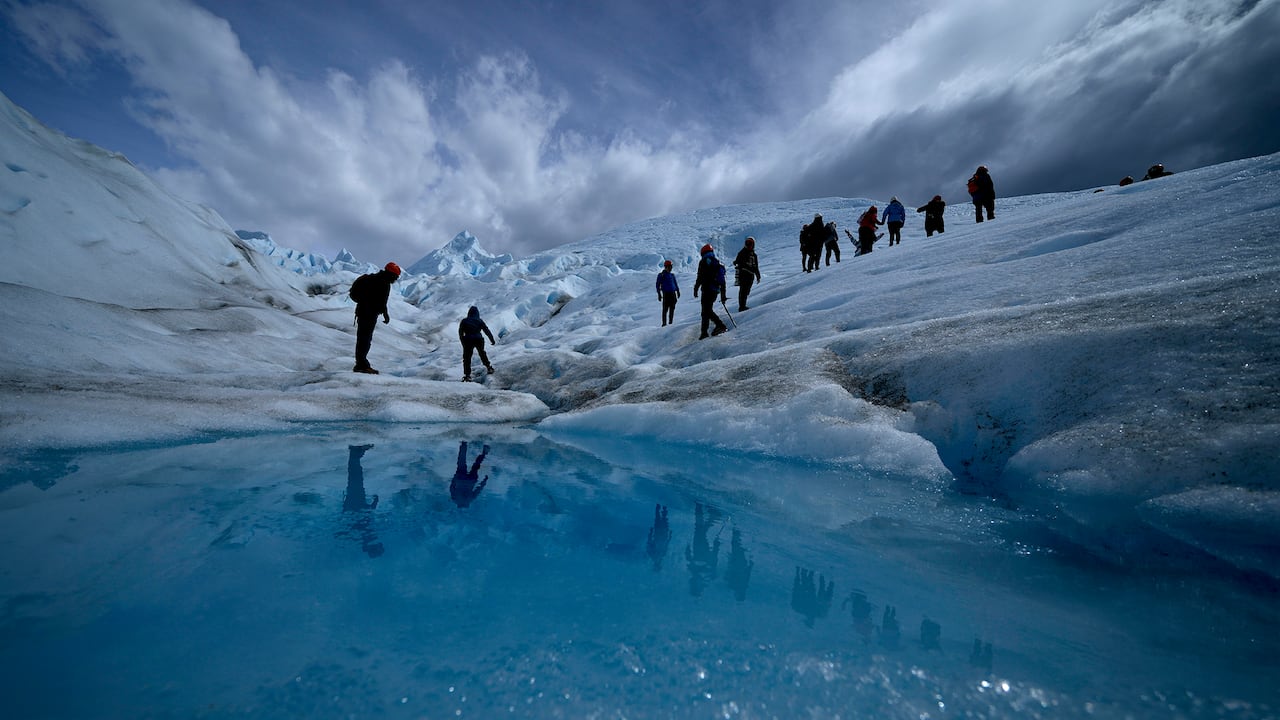 Turistas caminan sobre el glaciar Perito Moreno en el Parque Nacional Los Glaciares, cerca de El Calafate, Argentina, el martes 2 de noviembre de 2021. Los líderes mundiales se reúnen en Escocia en una cumbre climática de las Naciones Unidas, conocida como COP26, para impulsar a las naciones a aumentar sus esfuerzos para frenar el cambio climático. Los expertos dicen que la cantidad de energía desatada por el calentamiento planetario podría derretir gran parte del hielo del planeta, elevar el nivel global del mar y aumentar los eventos climáticos extremos. (Foto AP / Natacha Pisarenko)