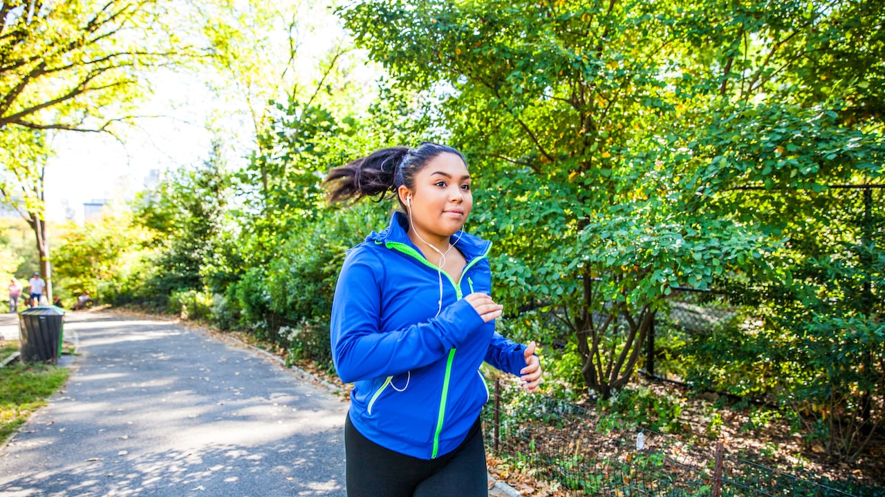 Mujer de talla grande corriendo en Central Park, Nueva York durante un hermoso día.