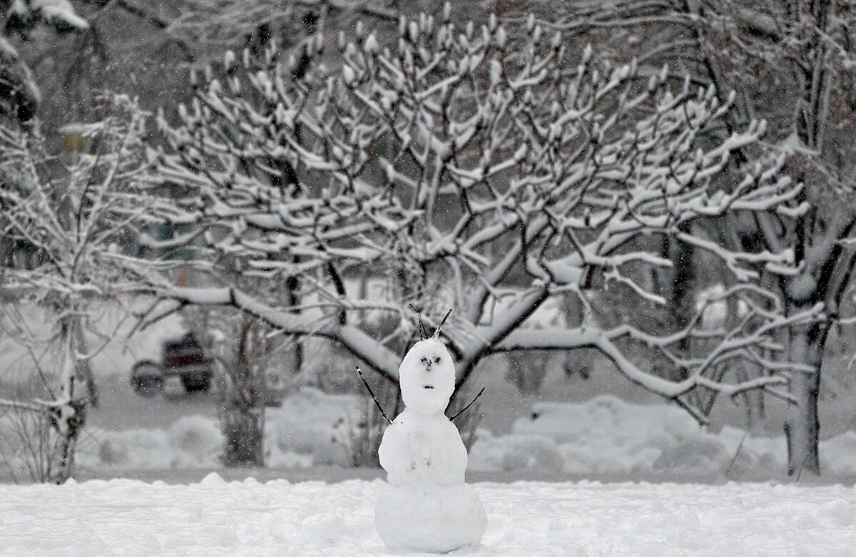 Un muñeco de nieve hecho por niños hace parte de un paisaje cubierto por la nieve en Bucarest, Rumania. (AP)