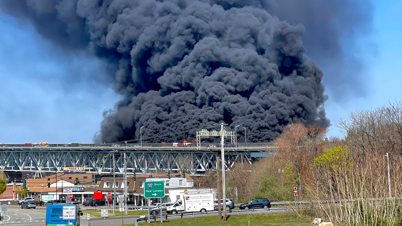 En esta foto provista por la Policía estatal de Connecticut, gruesas columnas de humo se alzan de un incendio provocado por el choque entre un camión cisterna de combustibles y un auto en el puente Gold Star Memorial en Groton, Connecticut, viernes 21 de abril de 2023. (Connecticut State Police via AP)
