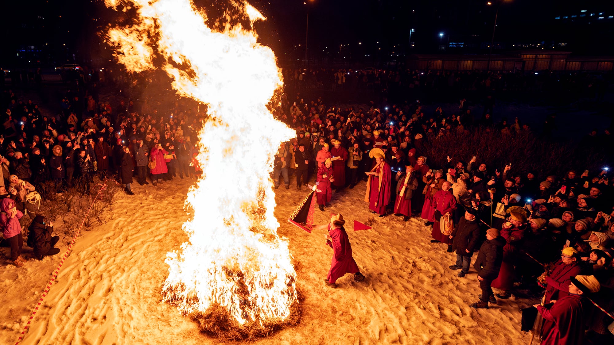 Los creyentes se reúnen alrededor de una hoguera durante el Dugzhuuba, un ritual budista de purificación previo al Año Nuevo, cerca del templo budista Datsan Gunzechoinei, en San Petersburgo, Rusia. Jueves 27 de febrero de 2025.