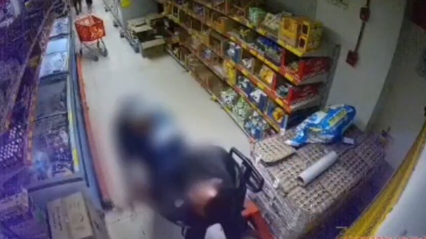 En la imagen, el guarda de seguridad forcejeando con el sujeto armado.