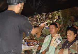 Jaime Pineda, alias ‘Jeremías’, dictando clase a guerrilleros. Frente a él, ‘Karina’. A la derecha Ilich Leonardo Rojas, docente de la Universidad Distrital detenido de camuflado y armado en La Macarena, Meta