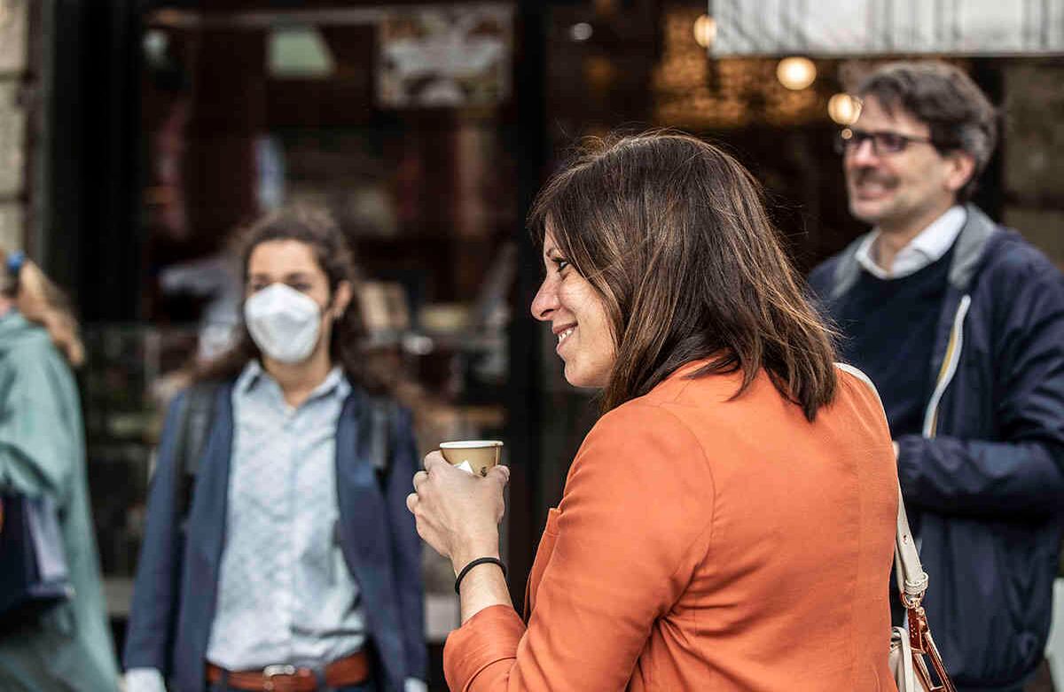Una mujer bebe café fuera de un bar en la estación de tren de Cadorna en Milán, Italia (AP Foto / Luca Bruno)