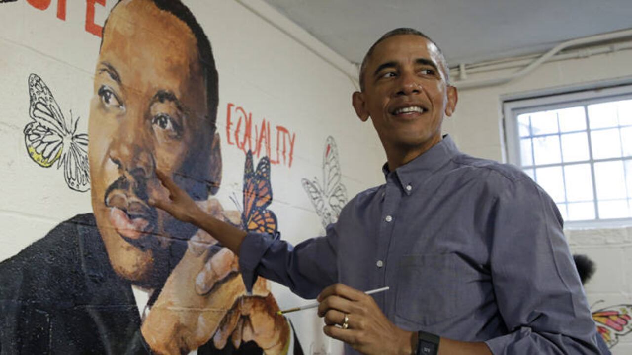 Obama ayuda a pintar el mural 'Pared de esperanza', creado por el artista Omatayo Akinbolajo, trabajando junto a una imagen de Martin Luther King Jr. Crédito: Yuri Gripas / AFP.