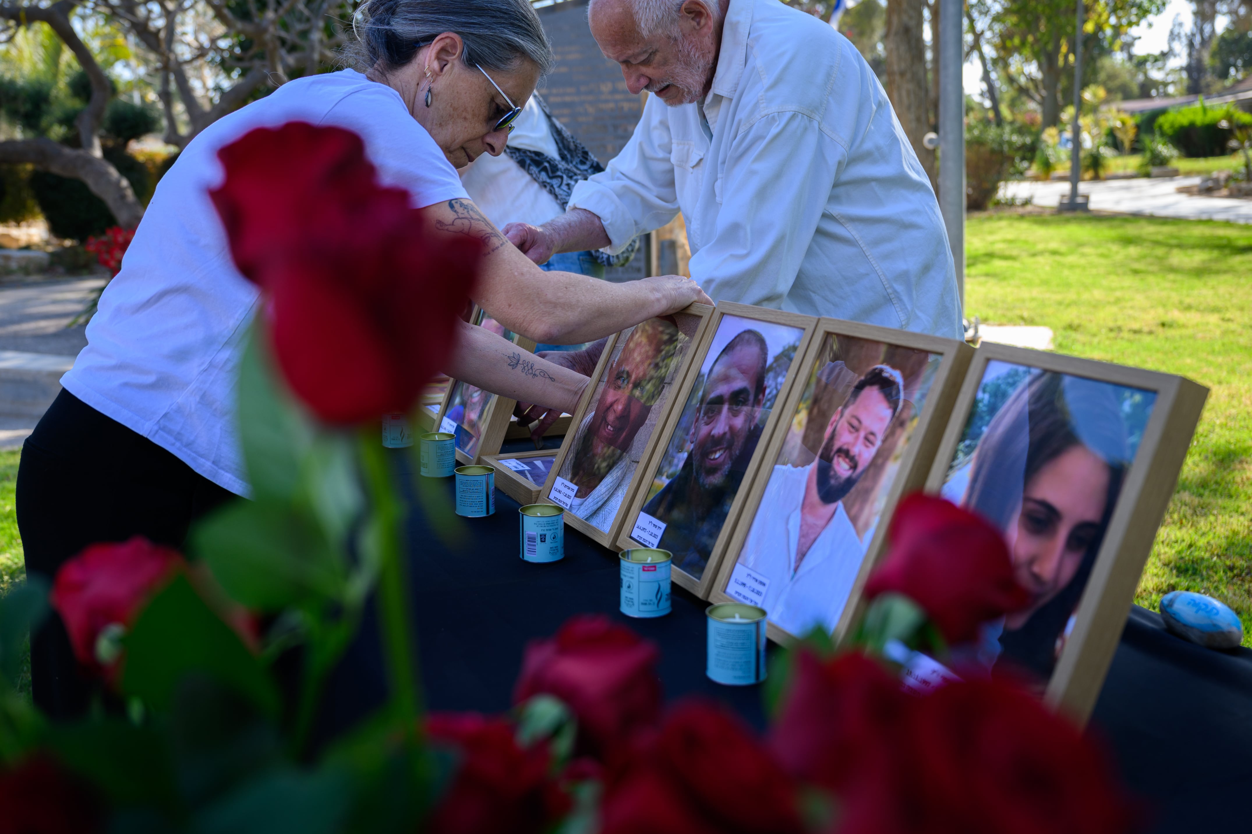 Personas disponen fotografías de miembros del kibutz que formaban parte del equipo de respuesta a emergencias de la comunidad y que fallecieron el 7 de octubre de 2023.