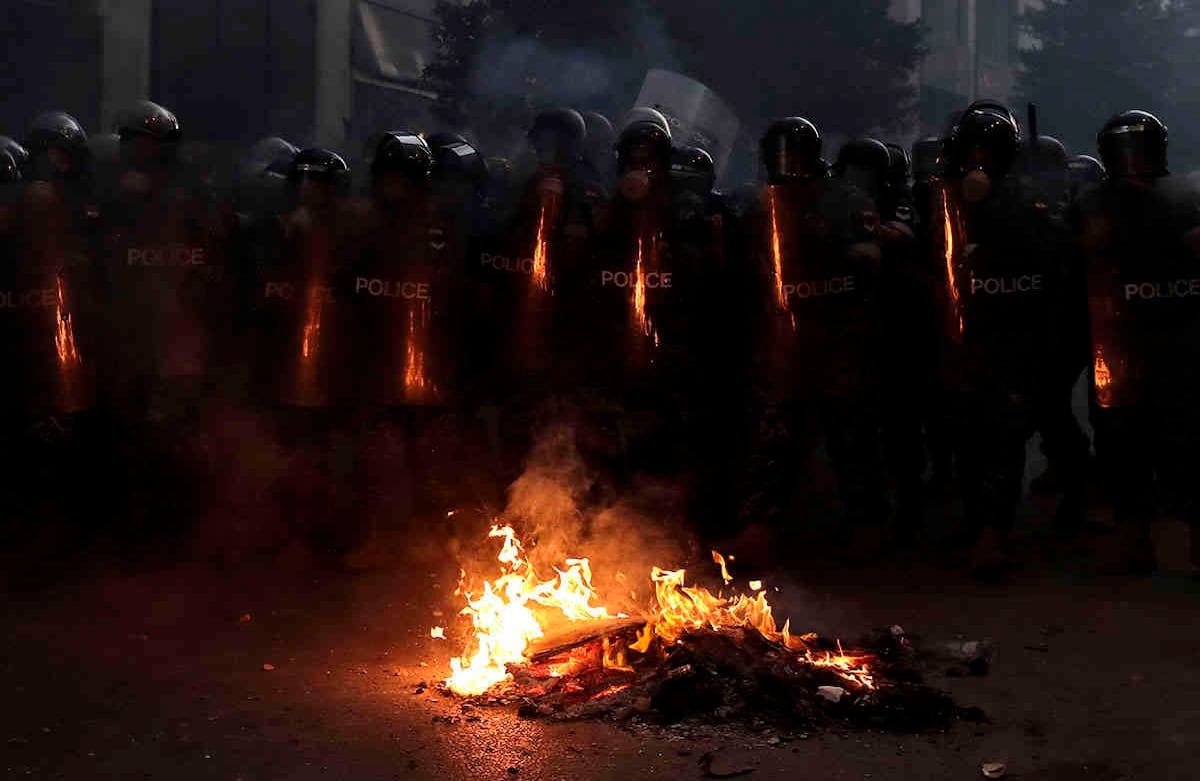 La policía antidisturbios avanza para hacer retroceder a los manifestantes antigubernamentales.  AP Photo / Hassan Ammar.