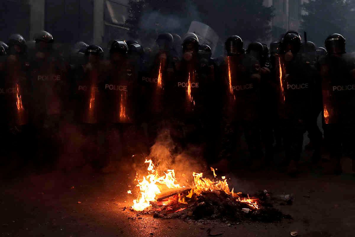 La policía antidisturbios avanza para hacer retroceder a los manifestantes antigubernamentales.  AP Photo / Hassan Ammar.