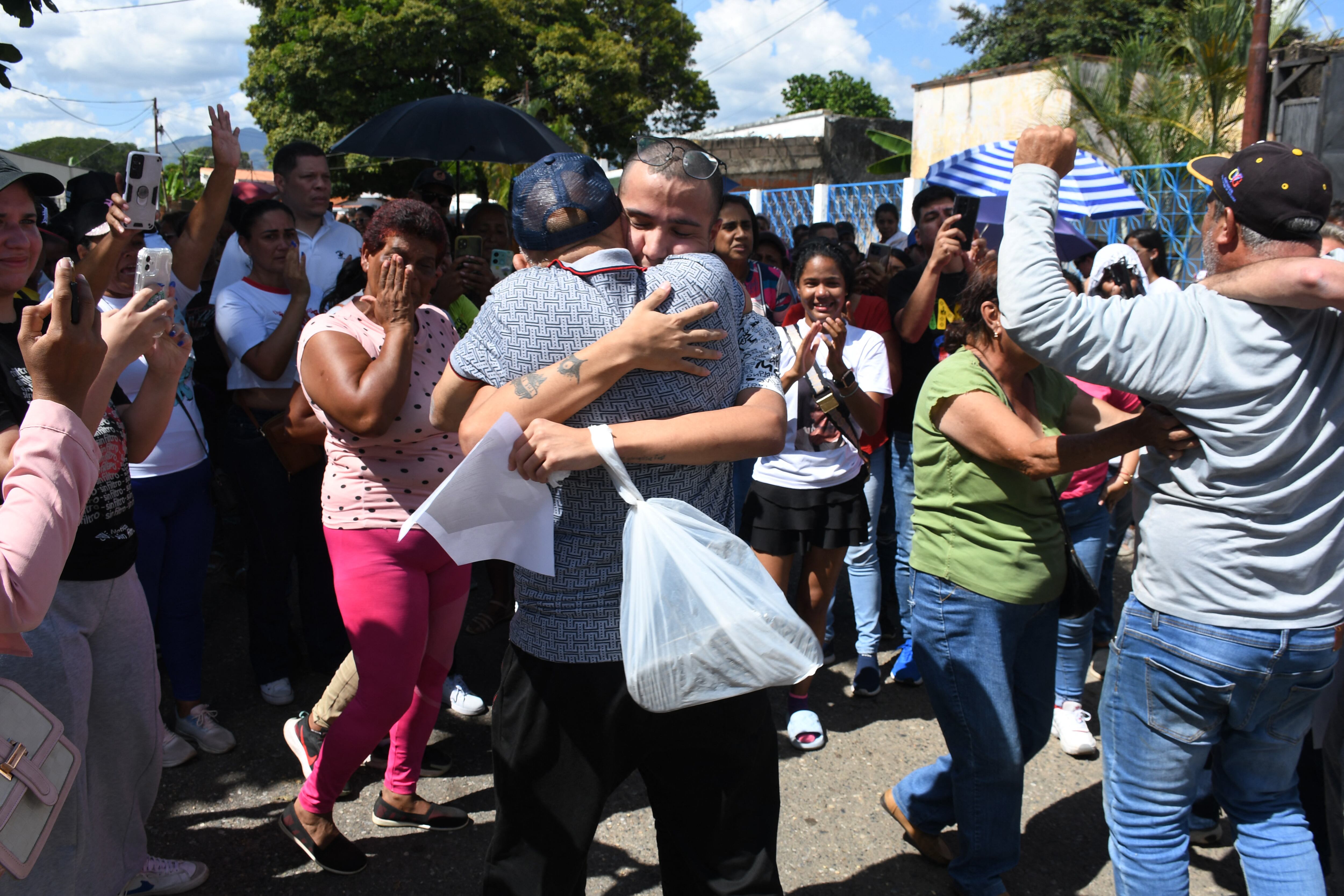 Un hombre arrestado durante las protestas posteriores a las disputadas elecciones presidenciales del 28 de julio abraza a un familiar después de su liberación afuera de la prisión de Tocuyito, en Tocuyito, estado de Carabobo, Venezuela, el 16 de noviembre de 2024. (Foto de Gabriela Pérez / AFP)