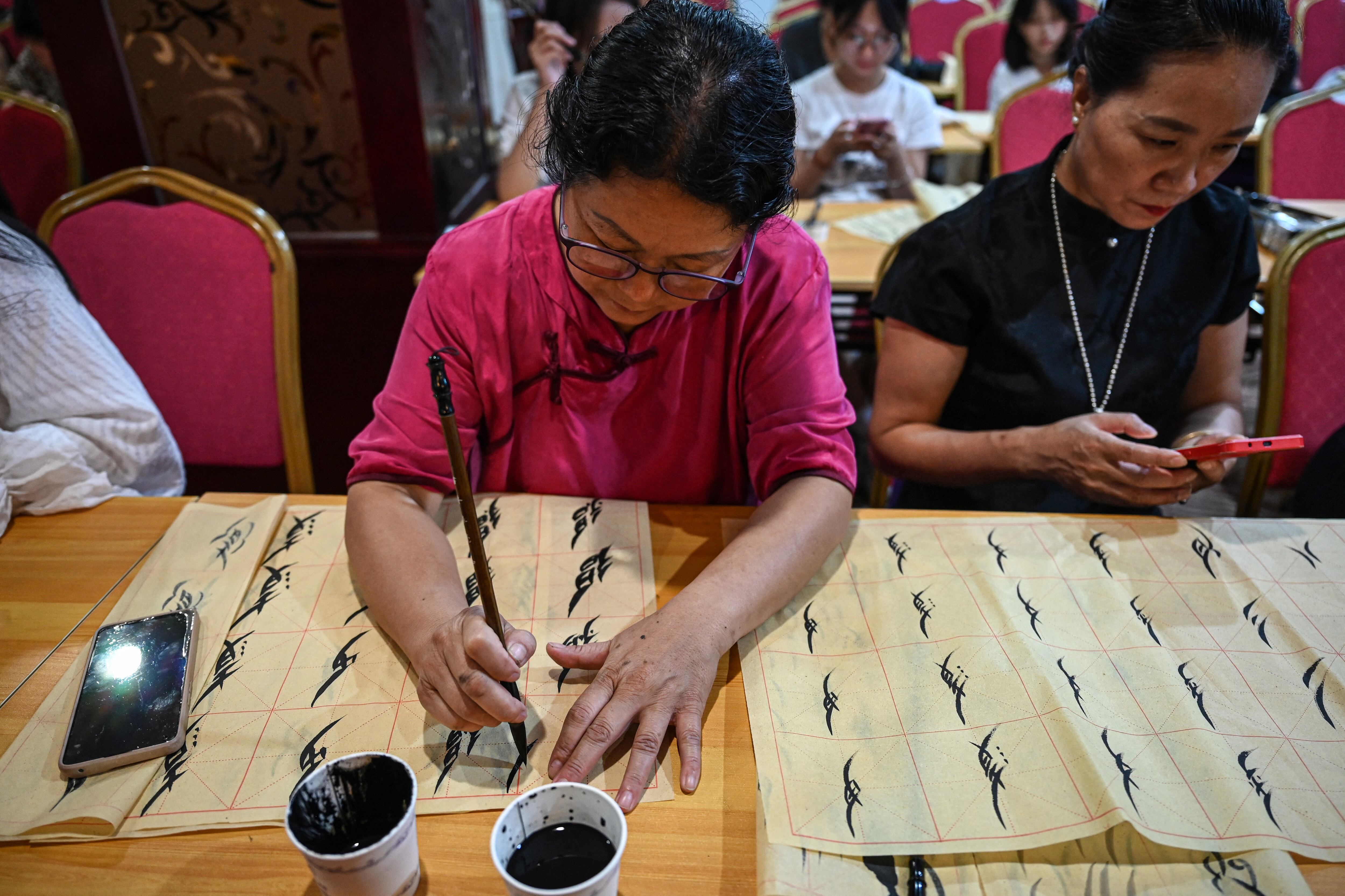 El Nushu, "escritura femenina", se creó hace unos 400 años, cuando las mujeres aún tenían prohibido asistir a la escuela. Aprendieron en secreto caracteres chinos y los adaptaron al Nushu, utilizando la escritura para comunicarse entre sí mediante cartas, canciones y bordados. Foto: Jade GAO / AFP