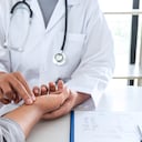 Doctor revisando la presión de medición en el pulso de la mano del paciente con las manos, concepto médico y de atención médica.